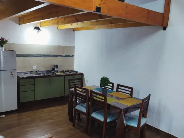 Cocina equipada con heladera, anafe y comedor para 6 personas en loft Yvyra