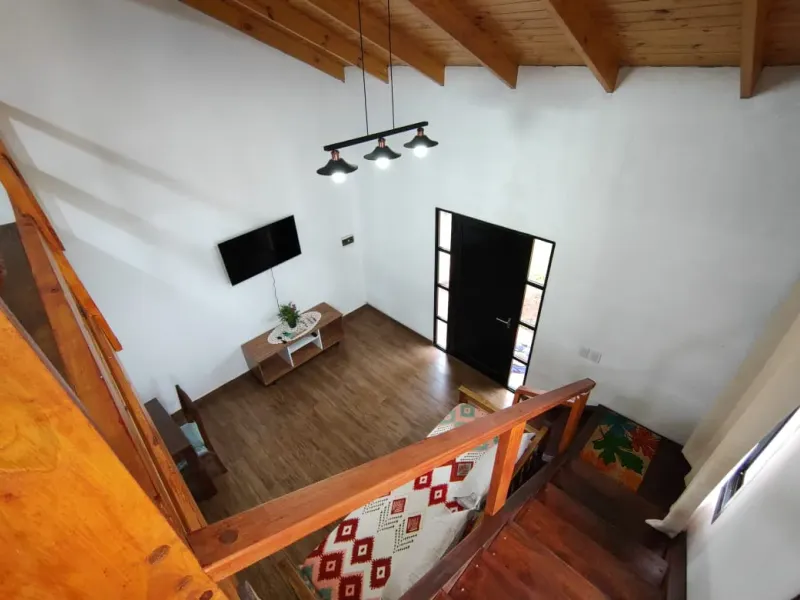 Interior de Loft 1: entrepiso de madera, living-comedor y cocina equipada