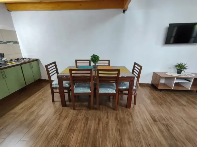 Interior de Loft 2: entrepiso de madera, living-comedor y cocina equipada
